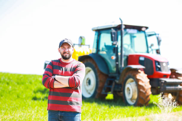 istock young farmer with arms folded in front of red tractor 1478533924