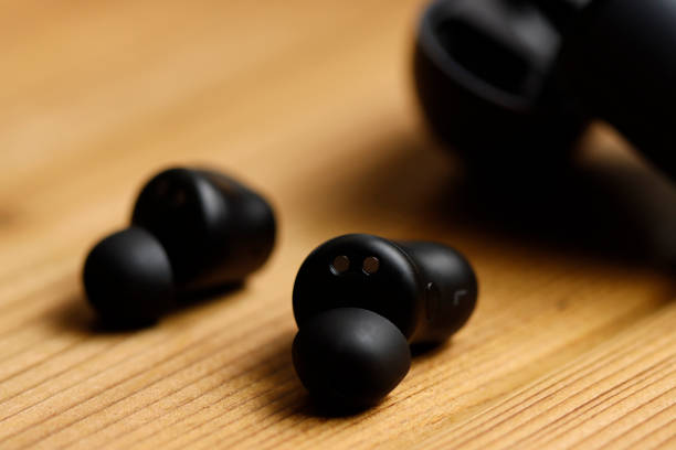 istock Black wireless earphones and wood background 1478548157