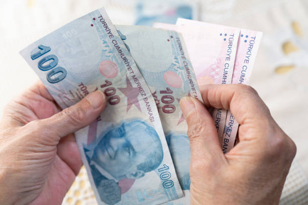 istock old women hands holding Turkish Lira banknotes 1478552174