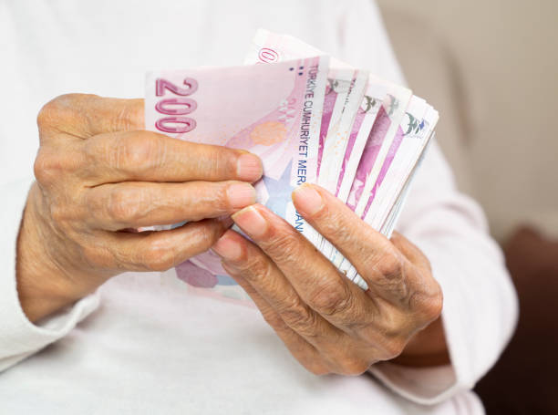 istock old women hands holding Turkish Lira banknotes 1478552214