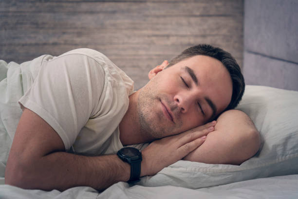 istock A satisfied expression on his face. young guy is resting in bed with a smartwatch on his hands. sleeping beautiful man 1478557132