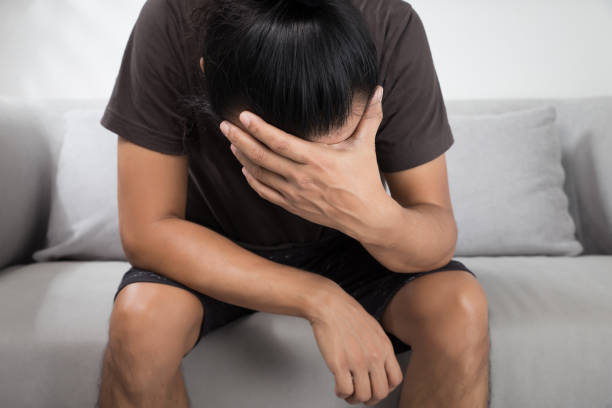 Headache Stressed man in the room. Depression and anxiety disorder concept. question mark depression sitting asking stock pictures, royalty-free photos & images