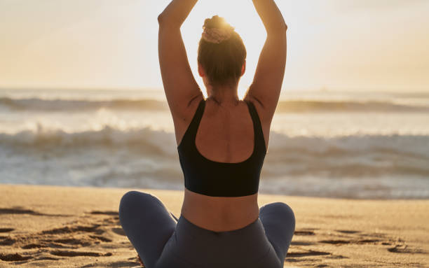 istock Slim woman doing yoga exercise on sandy beach 1478559239
