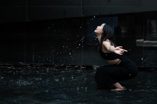 Women in black gym clothes play with water