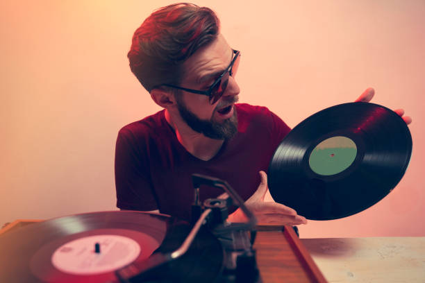 istock Retro style image, exited guy holding vinyl rerord in front of turntable 1478571957