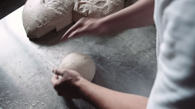 Small business owner. Baker prepares bread dough.