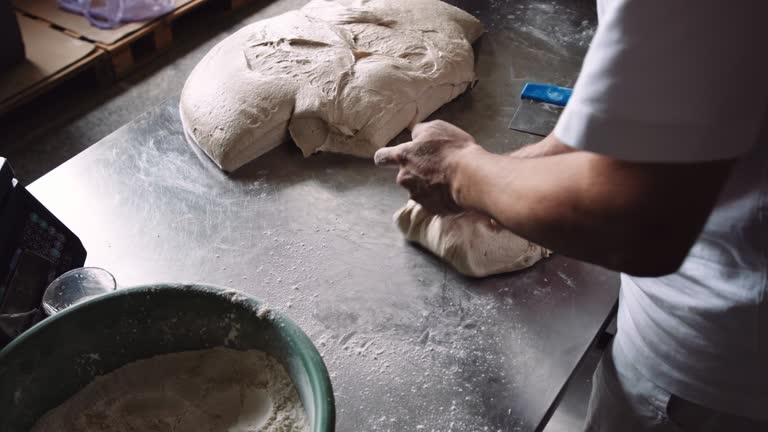 Small business owner. Baker prepares bread dough.