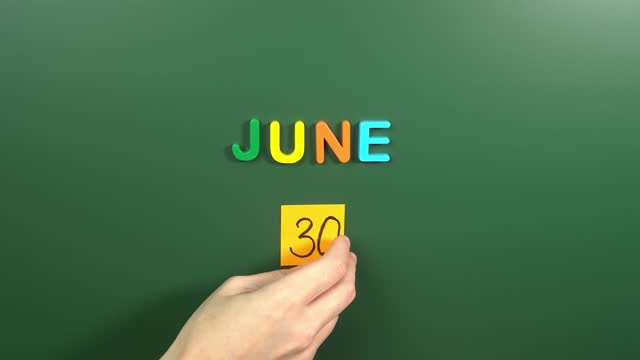 Hand sticking a sticker 30 June calendar day on school board. 30 date of June. Thirtieth day of June. 30th date number. 30 day calendar. Thirty date. Congo Independence, Social Media