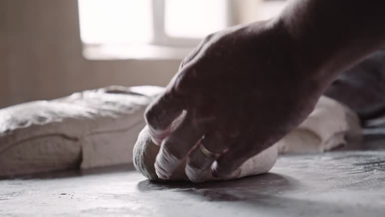 Small business owner. Baker prepares bread dough.