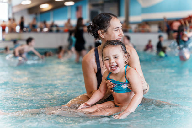 istock Little girl laughing while swimming with her mom 1478574232