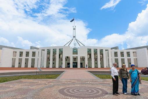 Canberra Australia January 23 2011;  Three tourists of Indian ethnicity standing for photo in forecourt of Australian Parliment buiding.