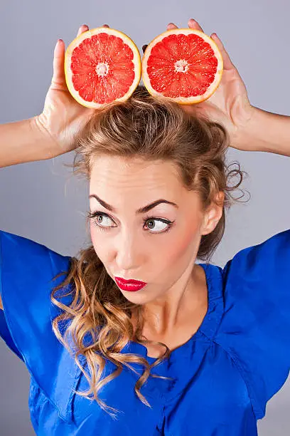 Beauty portrait of  young attractive, woman with grapefruit