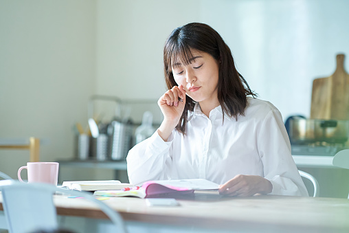 Adult woman studying with text at home