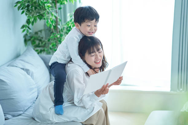 istock mother and boy sitting and reading picture book 1478592681