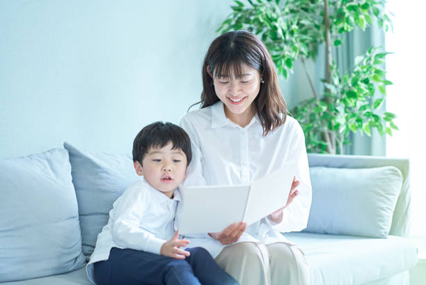istock mother and boy sitting and reading picture book 1478593467