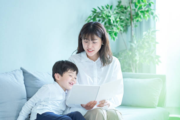 istock mother and boy sitting and reading picture book 1478594291