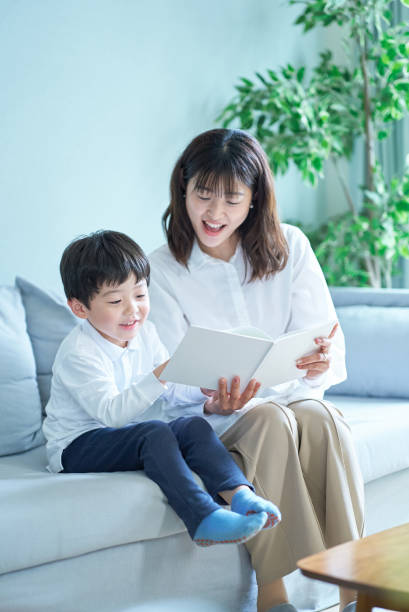 istock mother and boy sitting and reading picture book 1478594327