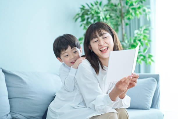 istock mother and boy sitting and reading picture book 1478594856