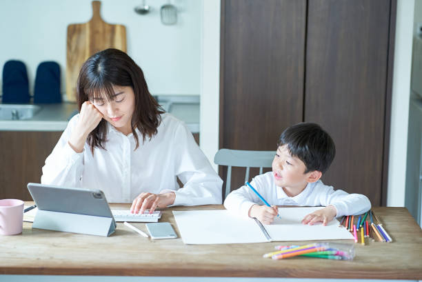 istock A child playing and a mother with a tired expression after working next door 1478600587