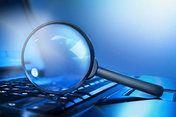 istock magnifying loupe on the laptop keyboard 147860345