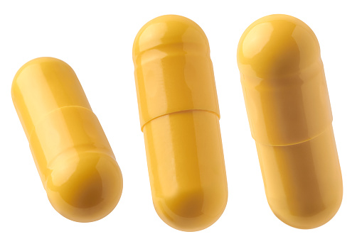 yellow gelatin capsules pills, oral medical drug filled with powder or liquid form isolated on white background, cut out