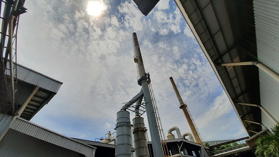Factory environment and chimneys from bottom view and blue sky