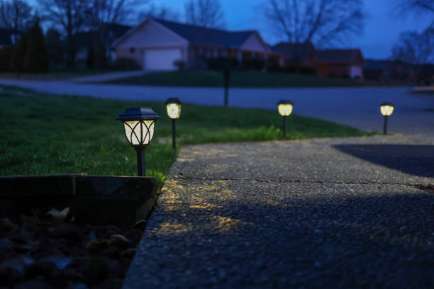 A serene twilight scene showcases a charming, softly lit pathway with glowing lamps in a tranquil garden