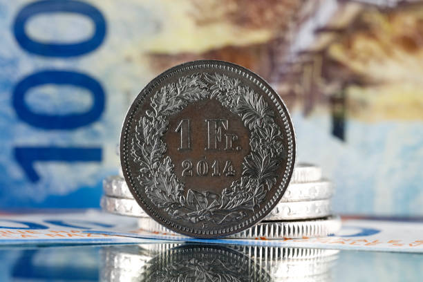 pièce d’un franc suisse et billet de cent francs - swiss currency coin swiss francs swiss coin photos et images de collection