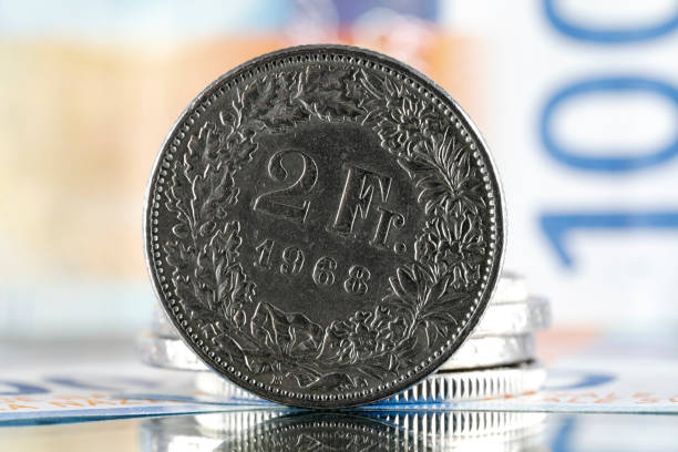 pièce de deux francs suisses et billet de cent francs - swiss currency coin swiss francs swiss coin photos et images de collection