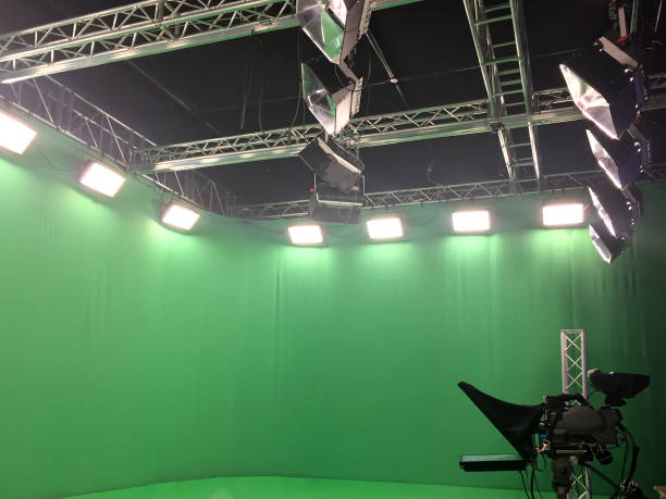 istock Modern empty green video recording and broadcasting studio with tv channel led screen and metalic stands, lights on 1478636609