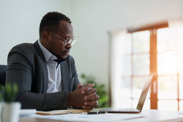 istock middle aged man American African using computer laptop with planning working on financial document, tax, exchange, accounting and Financial advisor 1478640519