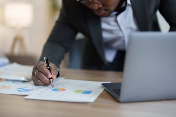 istock middle aged man American African using computer laptop with planning working on financial document, tax, exchange, accounting and Financial advisor. auditor or  audit concepts 1478641117