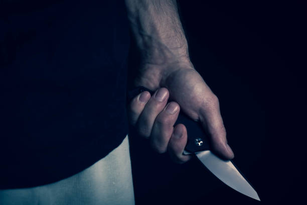 istock A sharp knife in the man's hand. The use of cold weapons. Knife attack . Armed raid. 1478642426