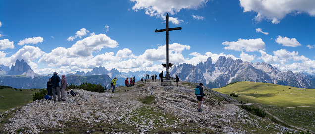 Amazing view of the Christian Cross made of wood on the top of Monte Specie. Relaxing context. Alpine or Dolomites landscape. Touristic destination. Summer time