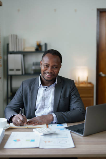 istock middle aged man American African using computer laptop with planning working on financial document, tax, exchange, accounting and Financial advisor. auditor or  audit concepts 1478642617
