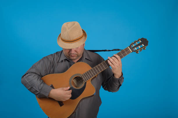 Two street musicians playing acoustic guitars near a modern building.