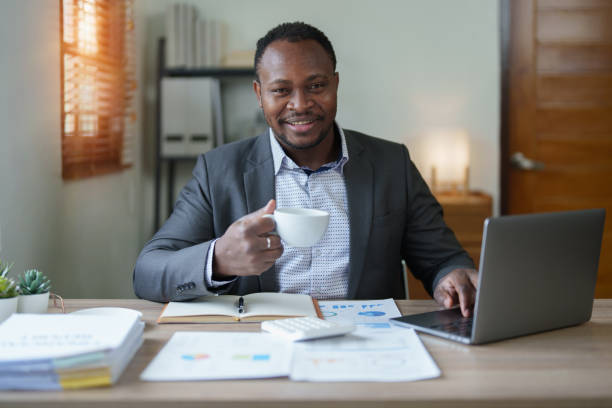 istock middle aged man American African using computer laptop with planning working on financial document, tax, exchange, accounting and Financial advisor 1478642785