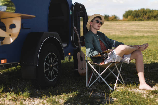istock Young man sitting in front of van enjoying summer time. 1478643649