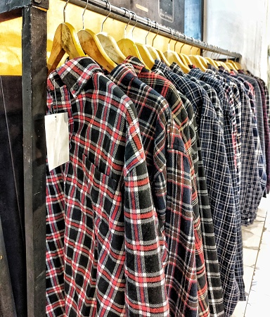 Flannel shirts hanging neatly.  Shirts for sale in a clothing store stock photo