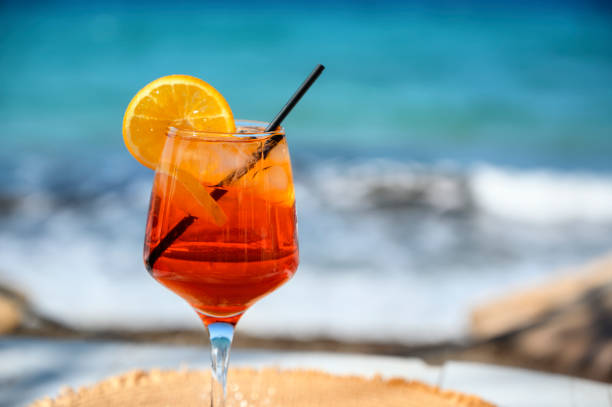 istock Red cocktail with orange slice and ice on a sea background 1478649525