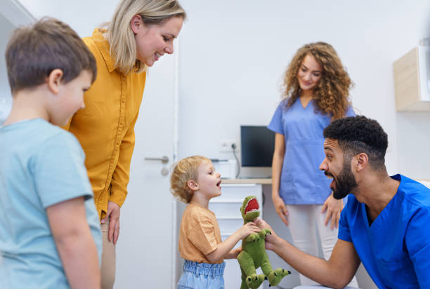 istock Young multiracial dentist playing with kids at his office. 1478650200