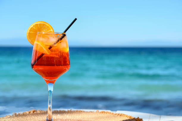 istock Red cocktail with orange slice and ice on a sea background 1478651030