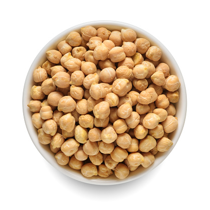 Raw chickpea beans in white bowl isolated on white background. Top view.