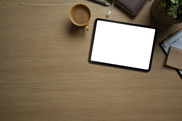 istock Flat lay, top view of simple workspace with digital tablet, cup of coffee and notebook on wooden table. 1478651978