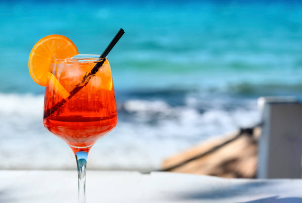 istock Red cocktail with orange slice and ice on a sea background 1478653263