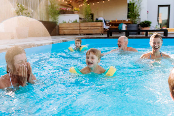 istock Multi generation family having fun and enjoying swimming in backyard pool during summer holiday. 1478653330