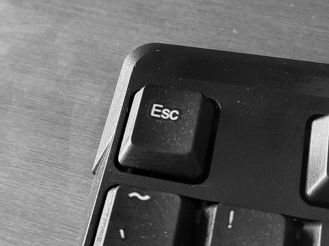 Computer keyboard with the word ESC on it. Black and white.