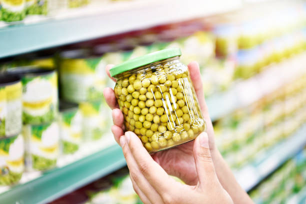 istock Green peas in jar in hands at shop 1478669564