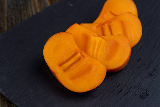 istock Sliced ripe orange pitted persimmon 1478670891