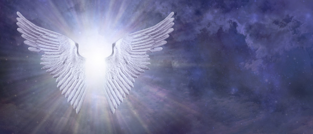Pair of outstretched Angel Wings with bright white light between against a blue night sky background with copy space for text